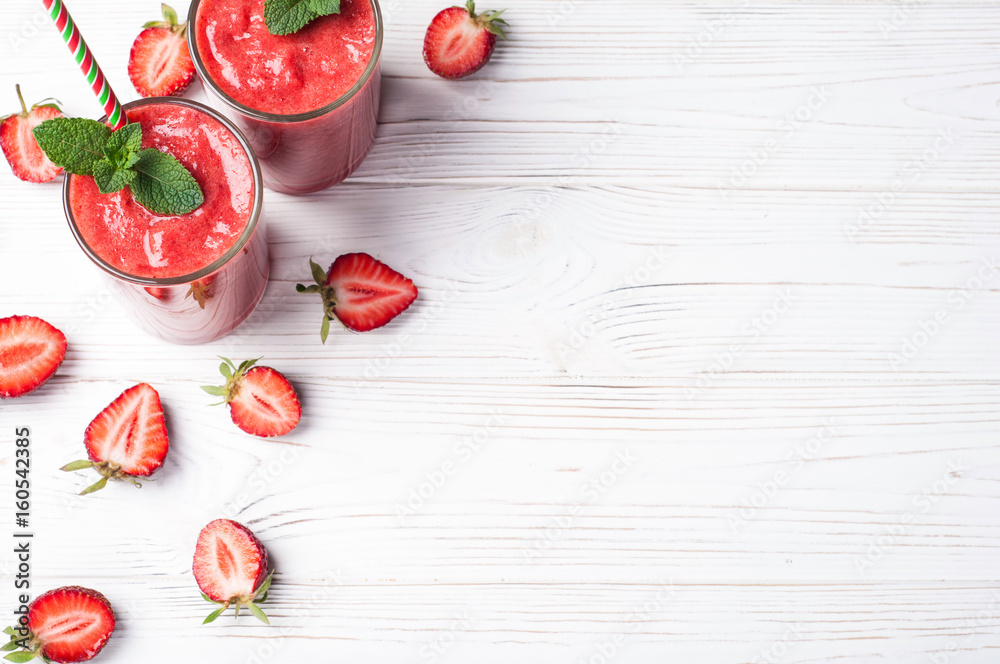 Strawberry smoothie in glass on white background with copy space. Summer drink cocktail. Healthy eating dieting and breakfast concept. Top view Strawberry smoothie in glass on white background with copy space. Summer drink cocktail. Healthy eating dieting and breakfast concept. Top view