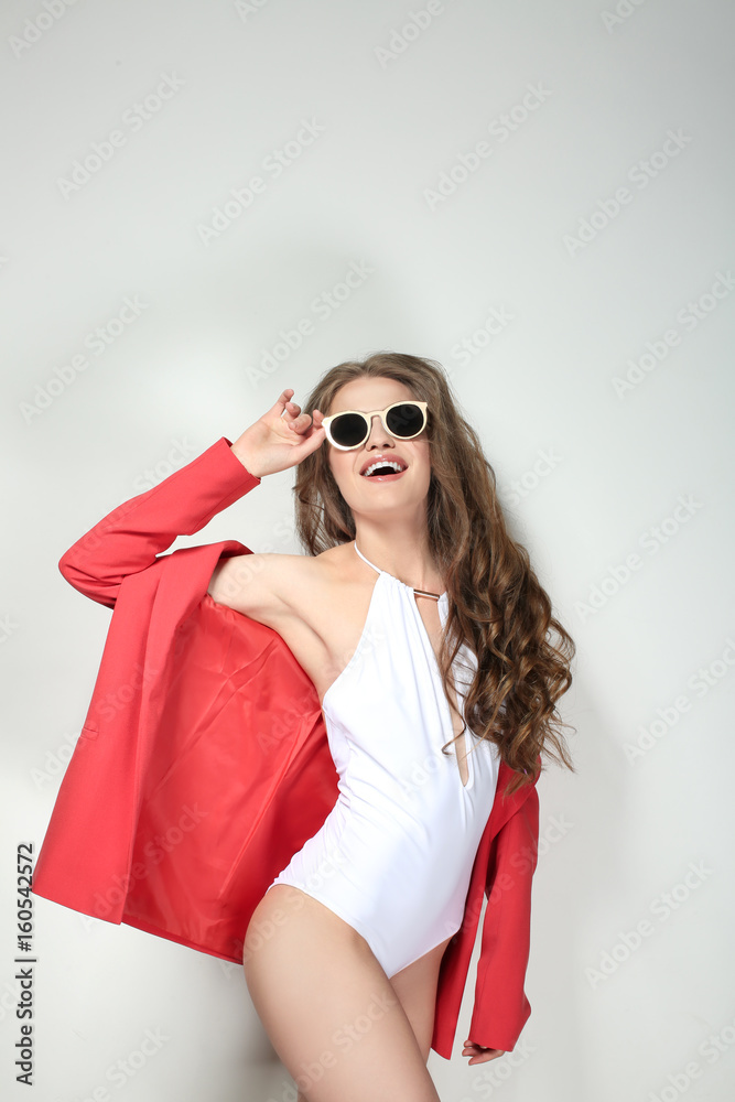 Beautiful young woman in beachwear on light background Beautiful young woman in beachwear on light background