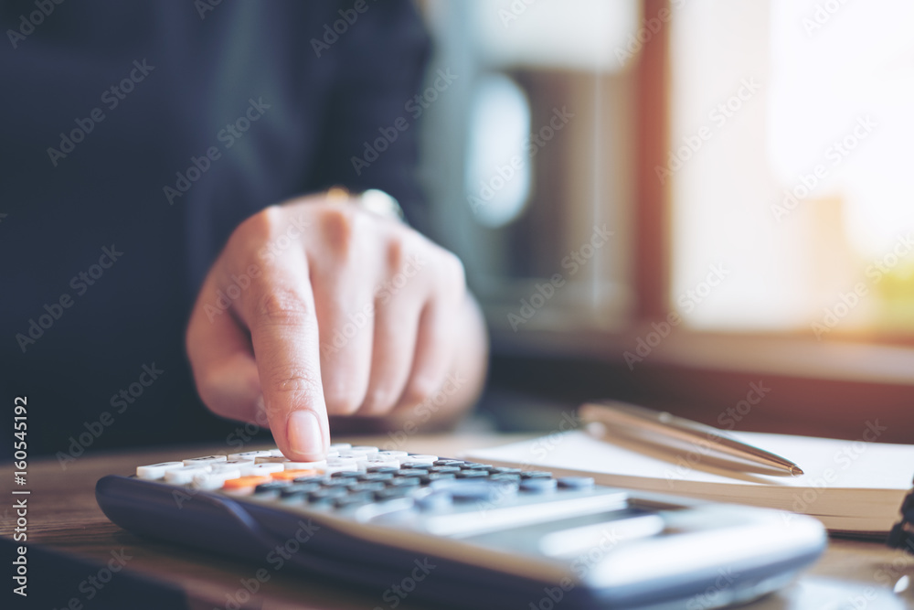 Closeup image of a business woman using calculator in office Closeup image of a business woman using calculator in office