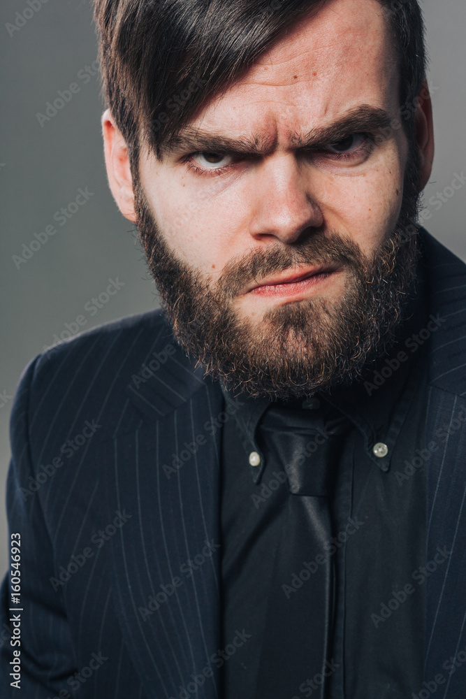 Obraz premium handsome unshaved man in black on grey wall