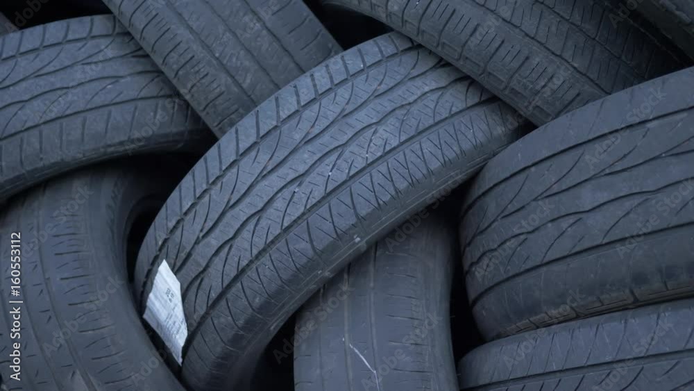 Closeup panning of a stack of car tires disposed Closeup panning of a stack of car tires disposed