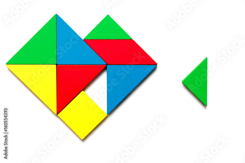Colorful wooden tangram puzzle in heart shape wait to fulfill with triangle shape on white background
