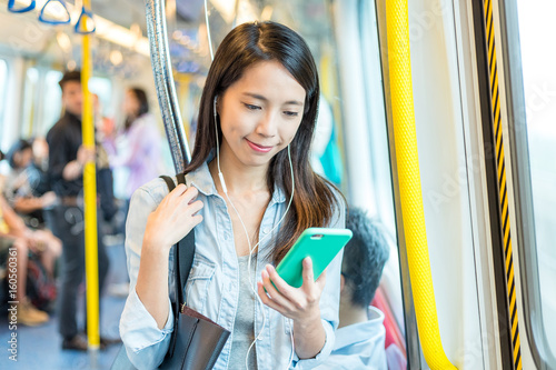 Canvas Print Woman listen to song on phone on train