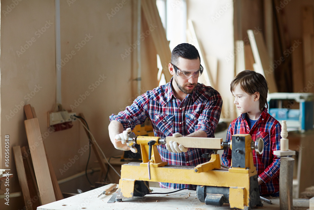 Father showing his son how to process wooden planks Father showing his son how to process wooden planks