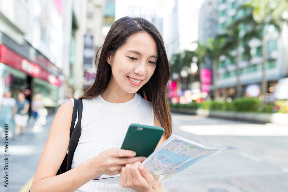 Woman use of cellphone and city map in Hong Kong city Woman use of cellphone and city map in Hong Kong city