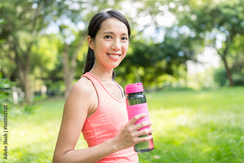 Sport woman drinking water in park Sport woman drinking water in park