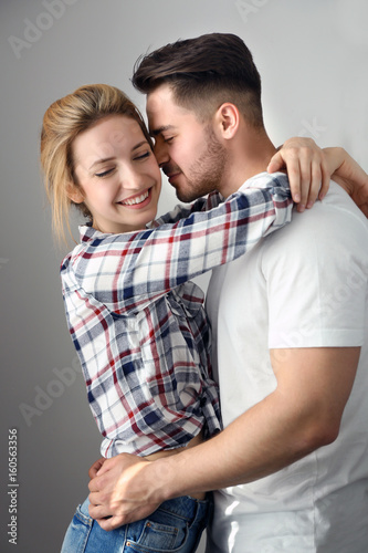 Happy young couple on light...