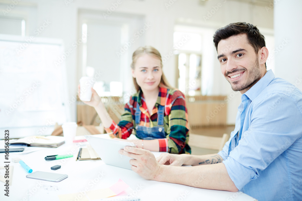 Obraz premium Two groupmates sitting by desk at lesson