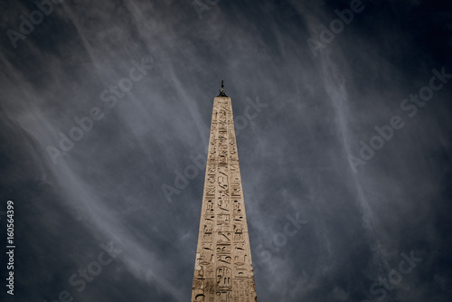 Fotografia Dramatic sky over old historical obelisk