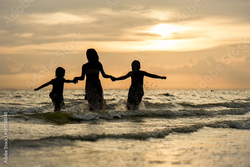 happy family run on beach during sunset time