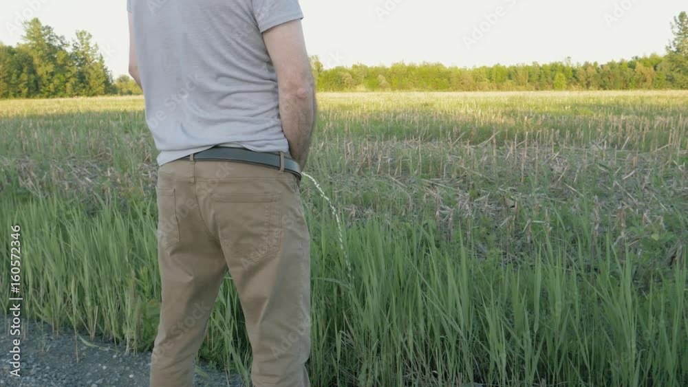 Man taking a piss on the side of the road.
