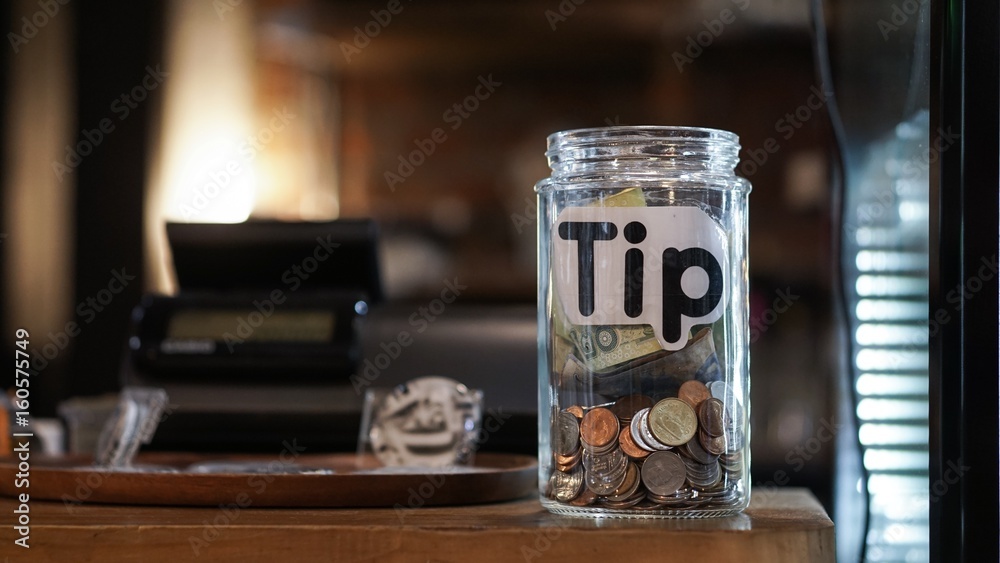 glass jar with thai baht coin on the cashier counter.