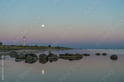 Skew lighthouse in the Baltic Sea. Shore, evening light, sunset, moon and architecture concept. Harilaid, small island in Estonia, Europe. photo