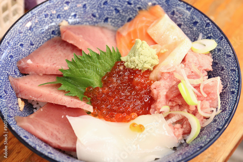 The salmon eggs or Ikura on the middle of raw fish bowl with octopus at Ameyoko market, Japan photo