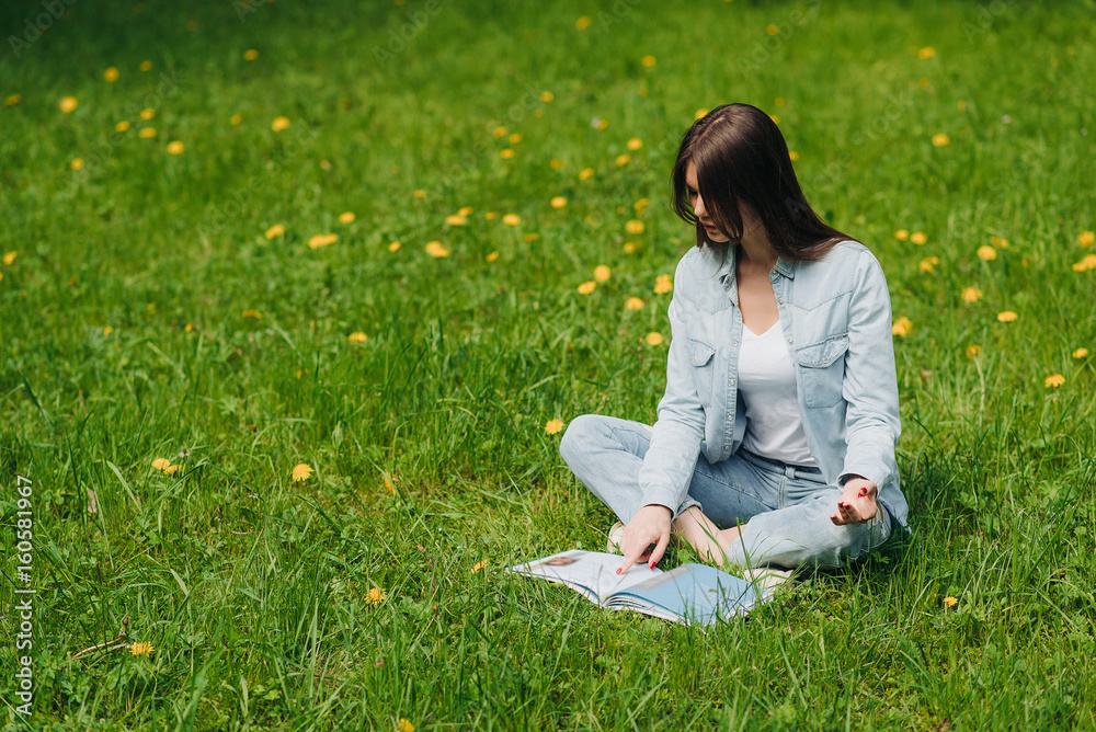 Woman reading on grass in park