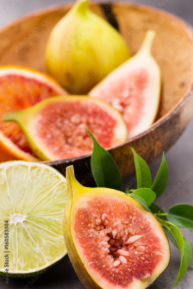 Mixed citrus fruit figs, limes on a gray background. Mixed citrus fruit figs, limes on a gray background.