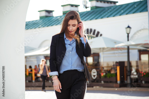 Beautiful woman with long healthy hair. Fashionable women's look with black jacket and blue blouse. Fashion concept.