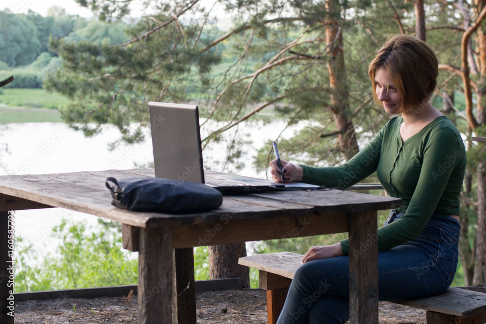 Fototapeta premium Beautiful young girl using her graphic tablet outdoors