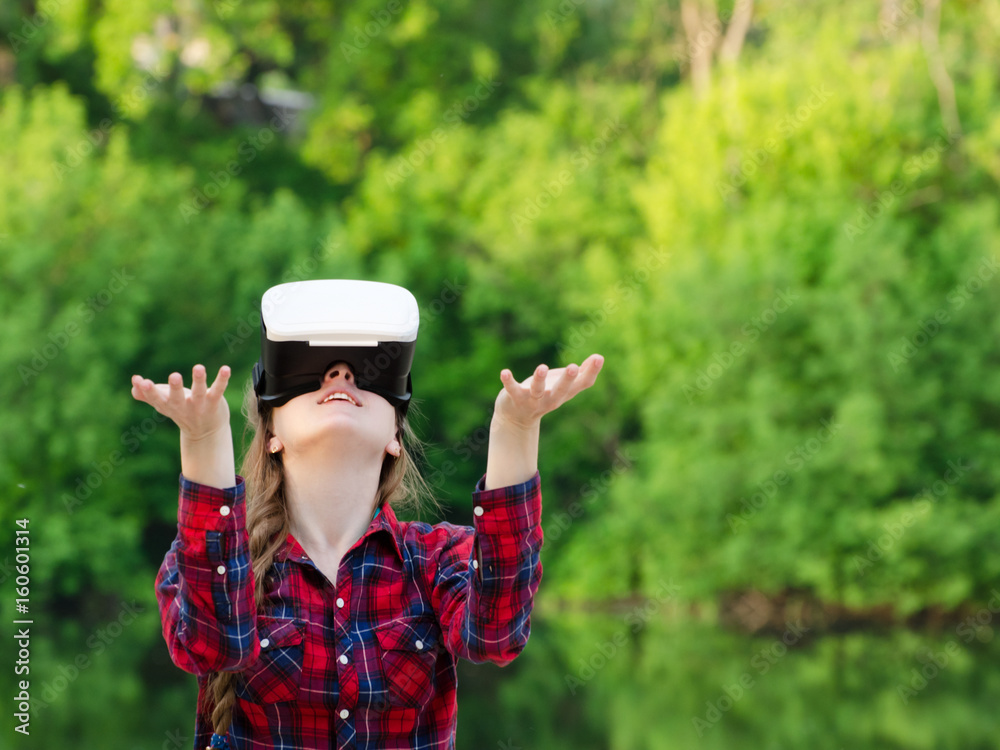 Girl in the helmet of virtual reality against the background of nature. Hands up Girl in the helmet of virtual reality against the background of nature. Hands up