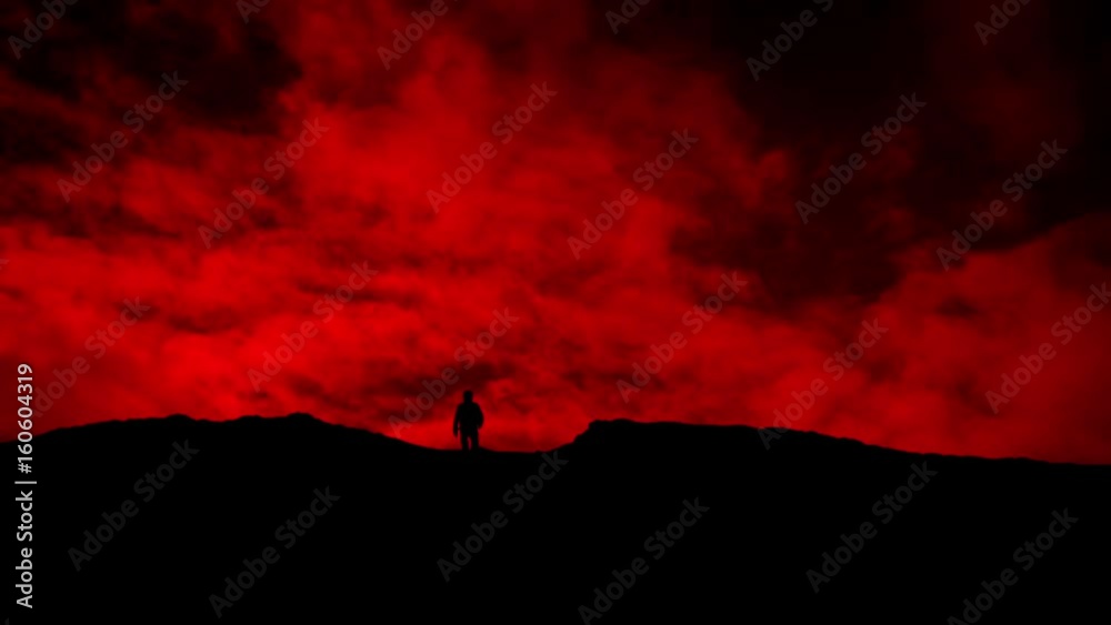 Man Approaches Over Hill On Red Sky Silhouette