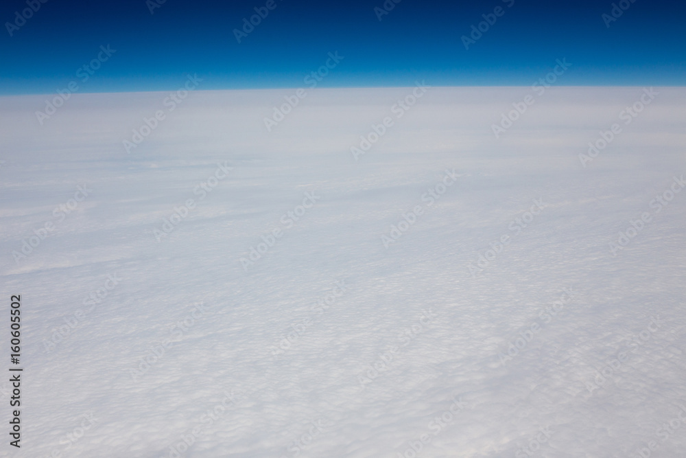 Above view of white clouds and a horizon with a blue sky. Above view of white clouds and a horizon with a blue sky.