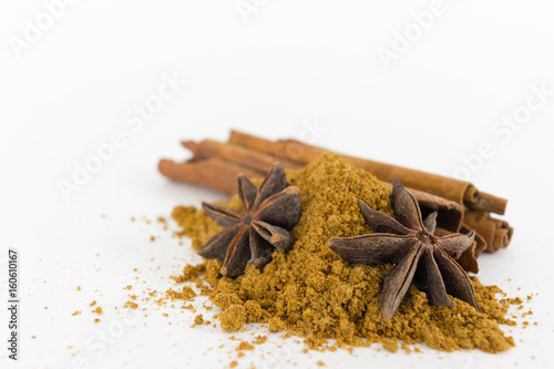 Flowers and cinnamon sticks with scattered powder on white background