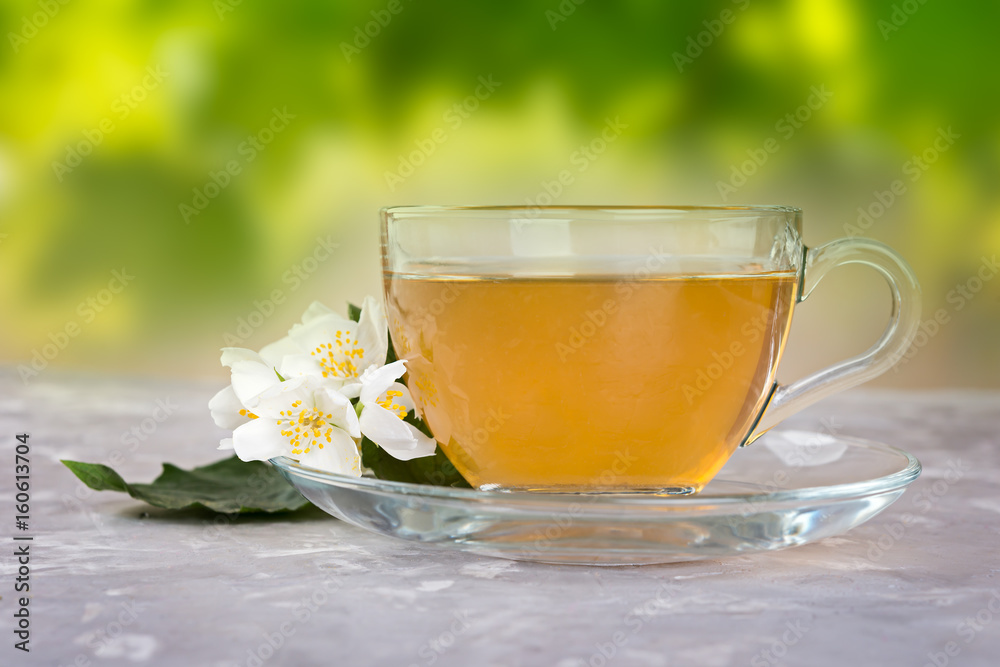 Jasmine tea with jasmine flowers on a grey stone table. Jasmine tea with jasmine flowers on a grey stone table.