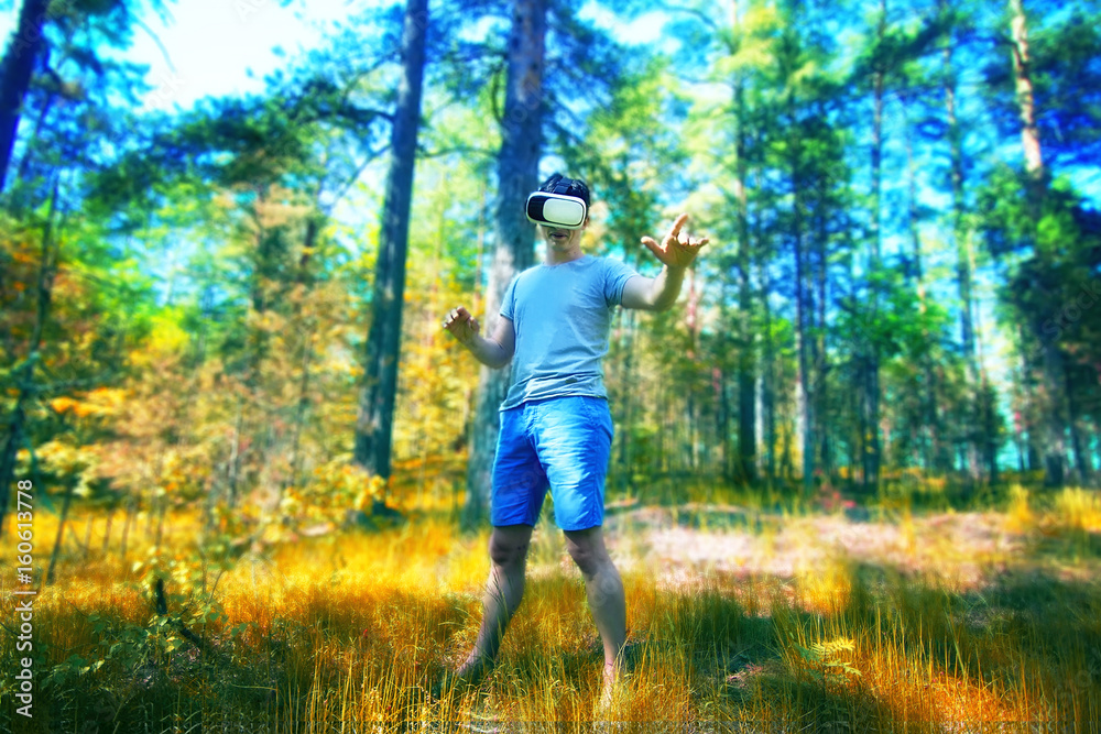 man in a VR glasses operating in virtual reality forest
