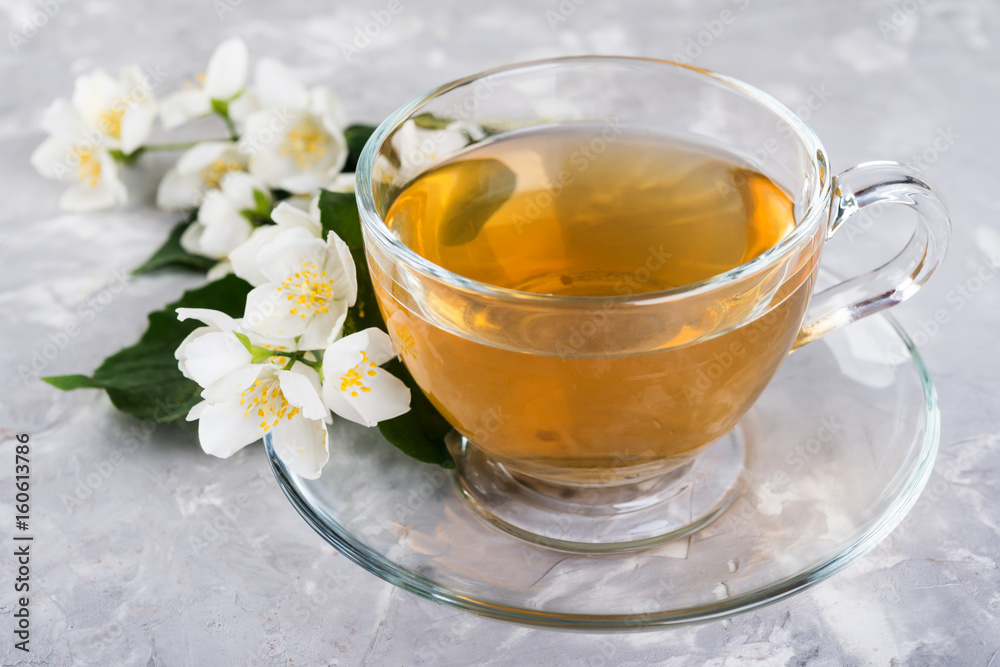 Jasmine tea with jasmine flowers on a grey stone table. Jasmine tea with jasmine flowers on a grey stone table.