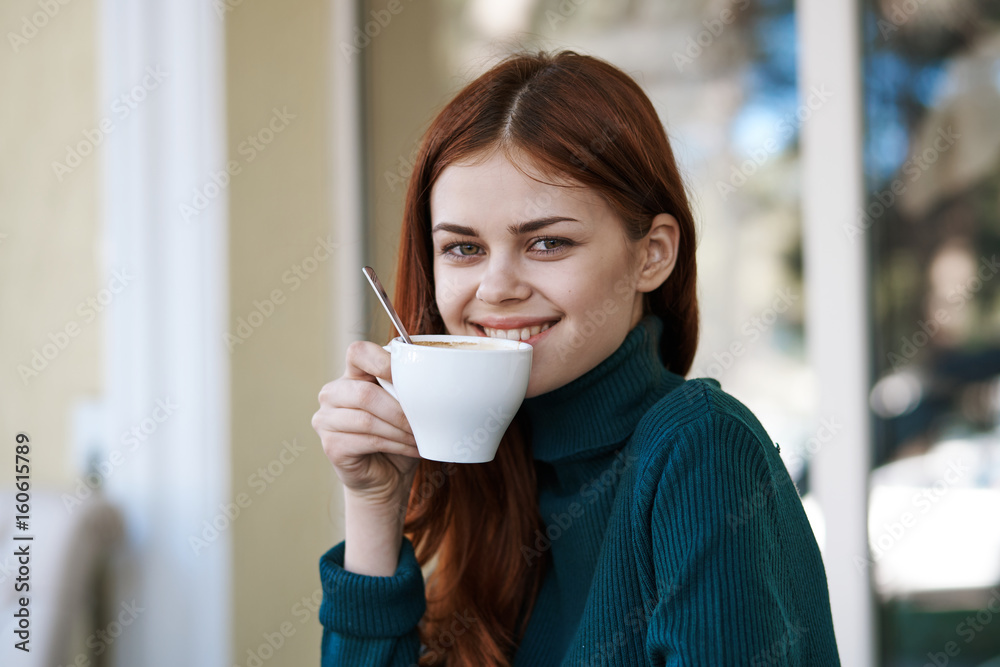 Woman sitting in cafe, young woman drinking from mug Woman sitting in cafe, young woman drinking from mug