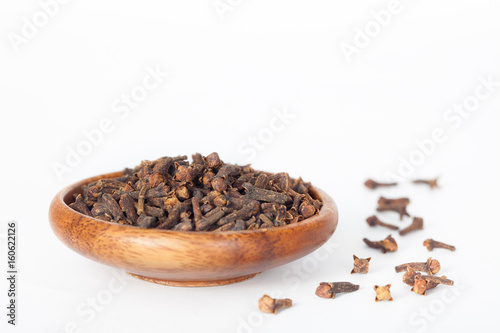 Cloves in wooden bowl on white background. Cloves have anti-carcinogenic properties. photo