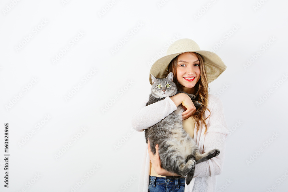 Smiling young woman with gray cat on white background Smiling young woman with gray cat on white background