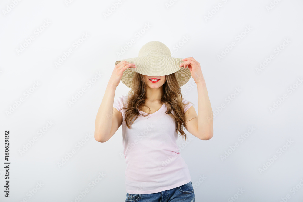 Woman covers face straw hat, red lips, smiling, upper half on white background Woman covers face straw hat, red lips, smiling, upper half on white background