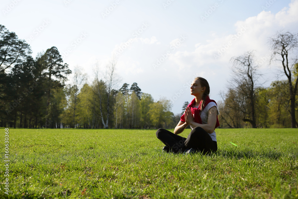 Meditating yoga young woman on grass, lotus, exercise, park, forest, space, trees, outdoor, natural background