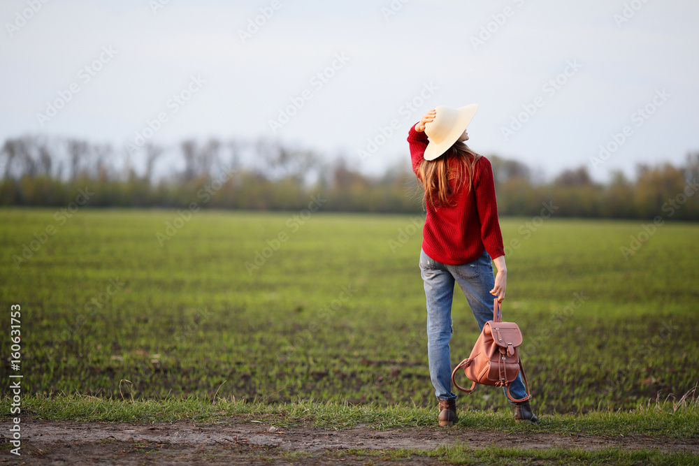 Woman standing back in field, natural background Woman standing back in field, natural background