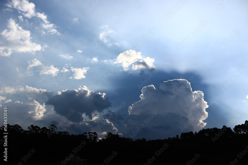 Photo of cloud blocking the sun and casting immense shadow in a blue sky