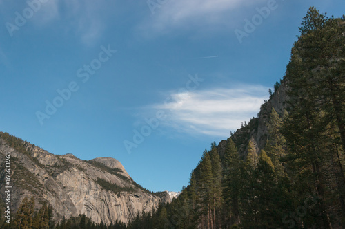 Photo of mountains and conifers against blue sky, Yosemite National Park, California, CA