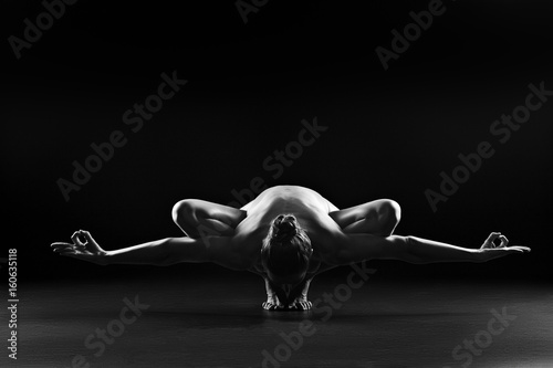 Nude woman practicing yoga exercise