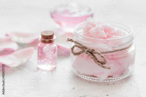 spa set with rose flowers extract and cosmetic for body on white desk background