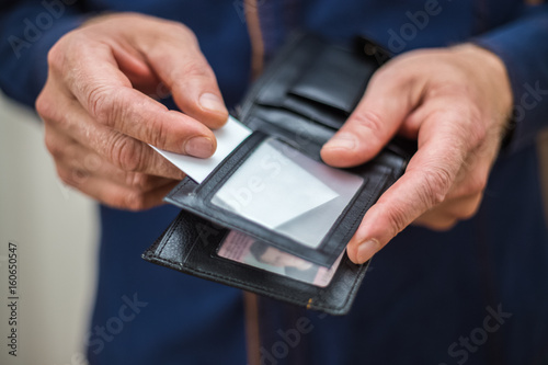 Bank card, business card, wallet, businessman holds in his hands and put the card in your wallet