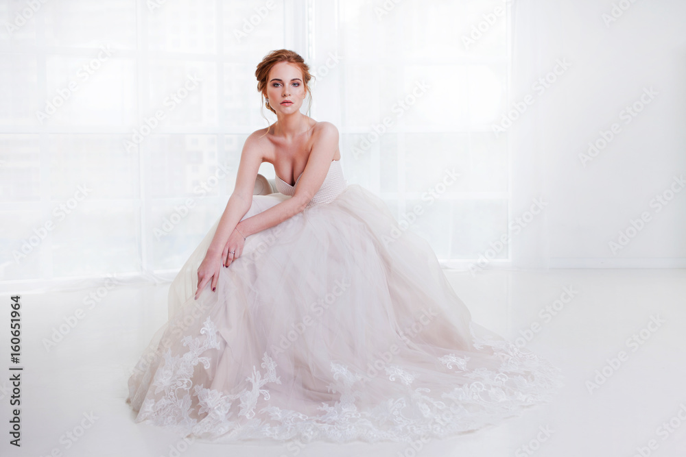 Portrait of a beautiful girl in a wedding dress. Bride in luxurious dress sitting on a chair Portrait of a beautiful girl in a wedding dress. Bride in luxurious dress sitting on a chair