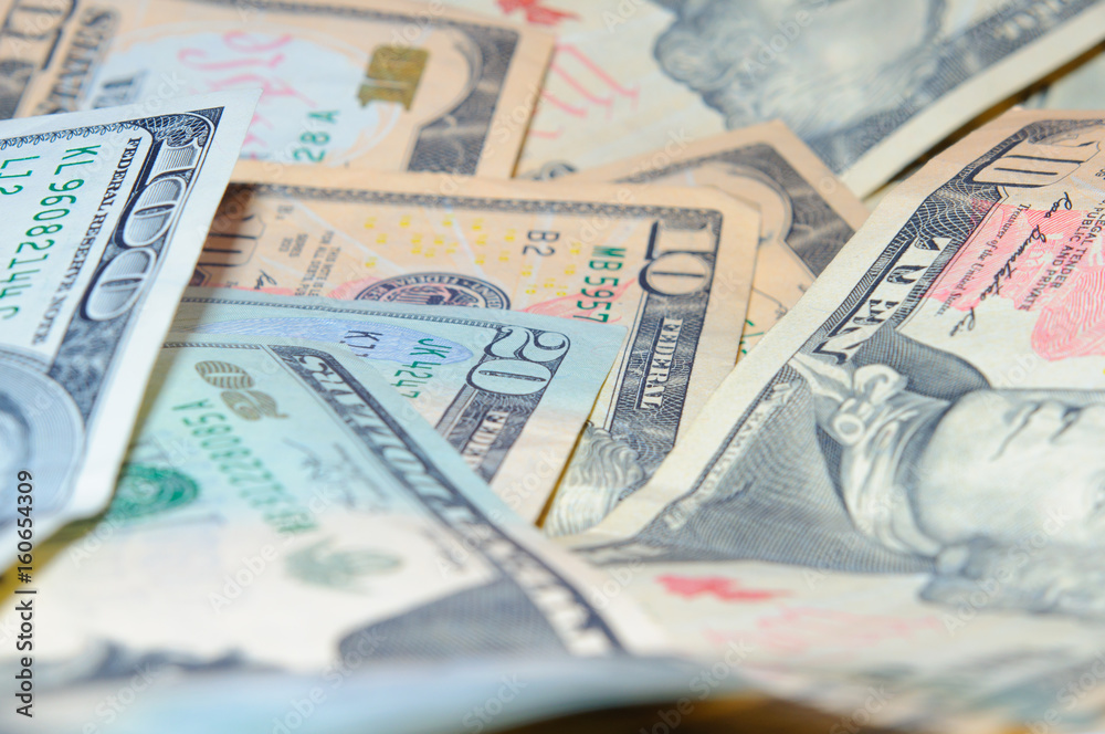 Scattered banknotes of ten, twenty, and one hundred dollars Scattered banknotes of ten, twenty, and one hundred dollars