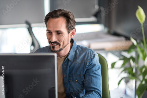 Cheerful busy male person working in office