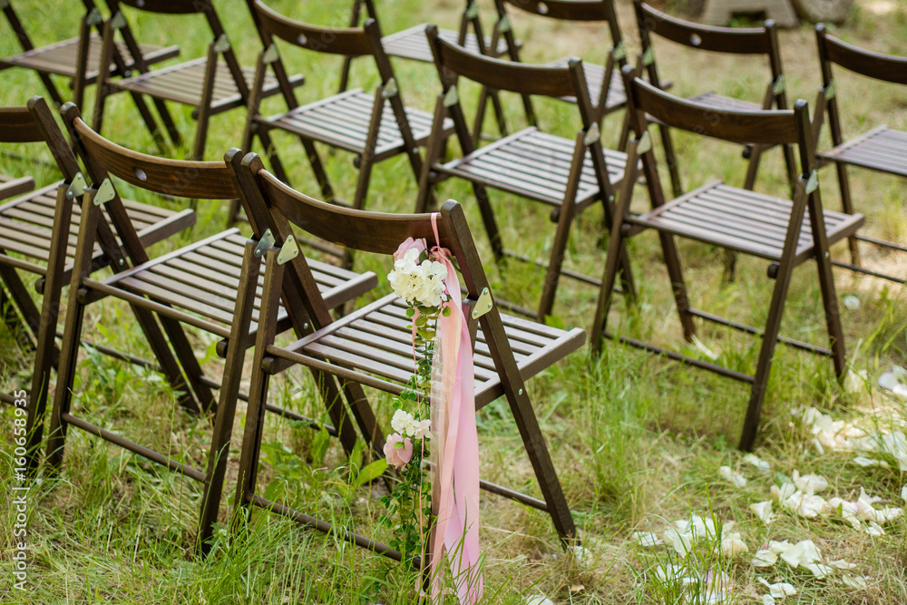 Beautifully decorated chairs for wedding reception outdoors. Wedding decor.