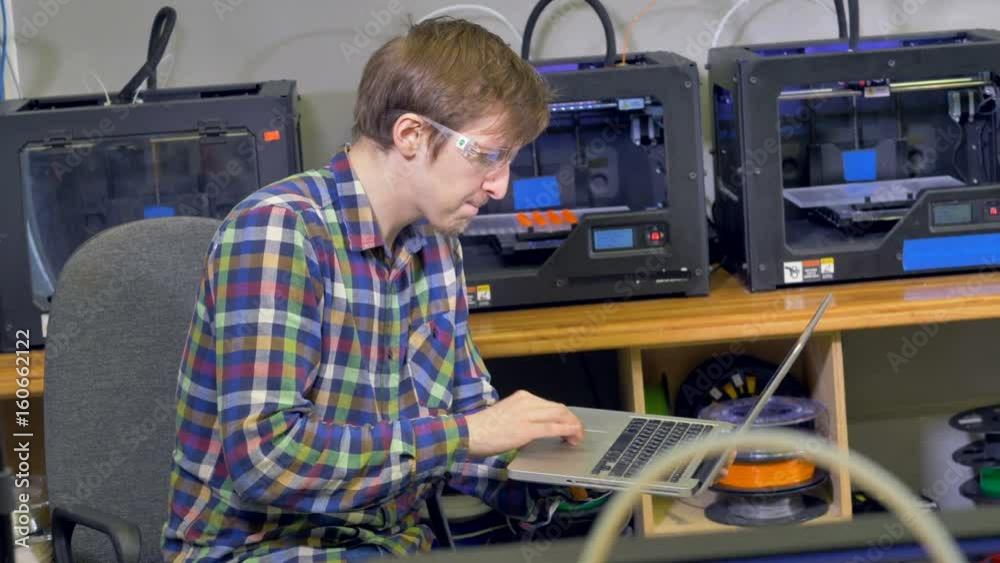 The worker is controling the process of plastic model creation. 3D printing. The worker is controling the process of plastic model creation. 3D printing.