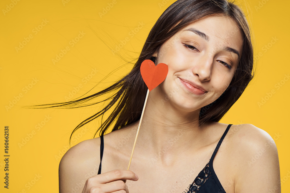 Beautiful, young woman, woman with a smirk with a heart on a stick ...