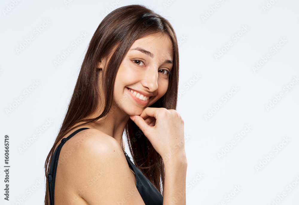 Woman smiling, woman leaning her hand to face on a light background Woman smiling, woman leaning her hand to face on a light background
