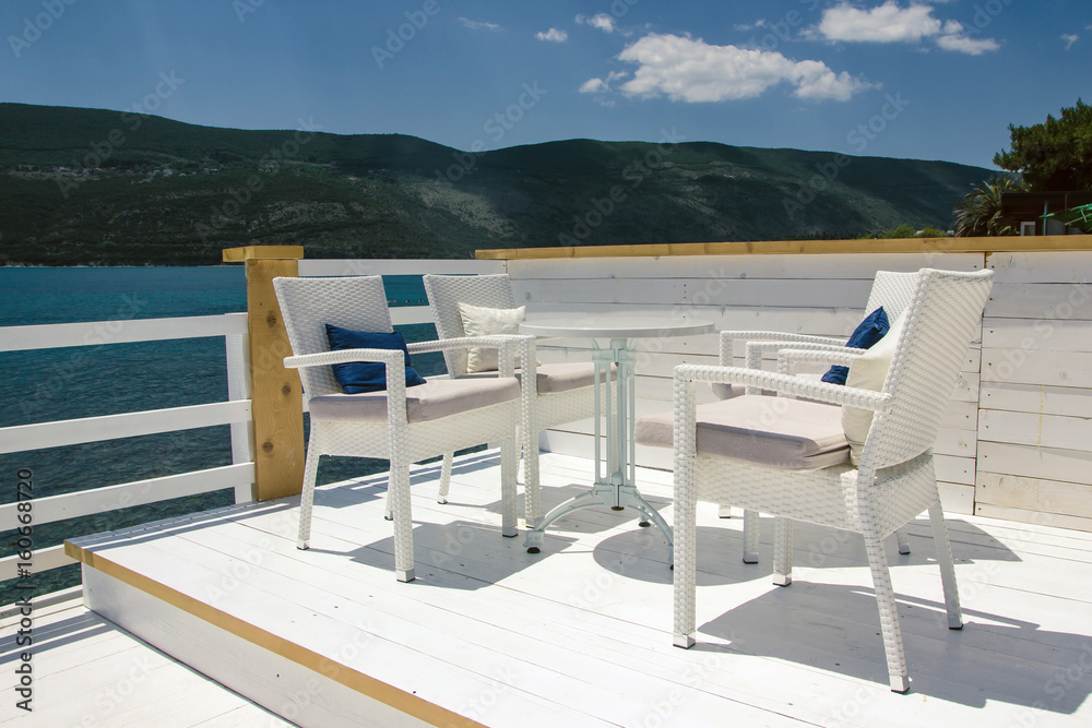 Fototapeta premium Summer restaurant empty white chair and table.