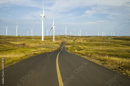 Asphalt road and wind turbines © zhengzaishanchu