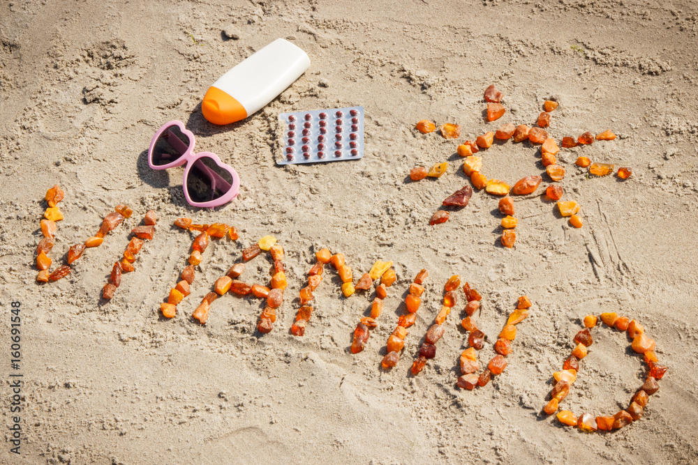 Medical pills, inscription vitamin D and accessories for sunbathing at